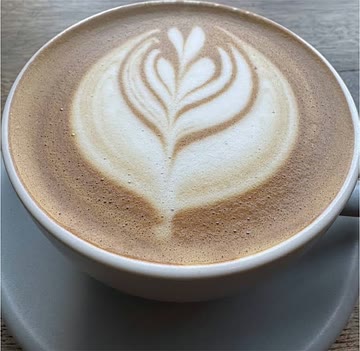 A cup of coffee with leaf-patterned latte art