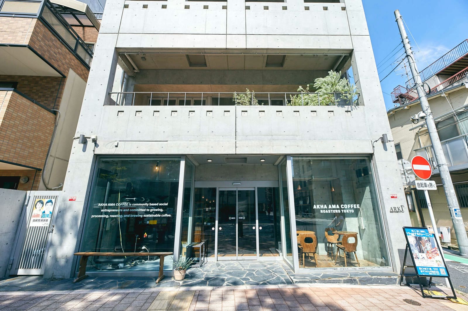 The exterior of Akha Ama Coffee on the ground floor of a concrete building