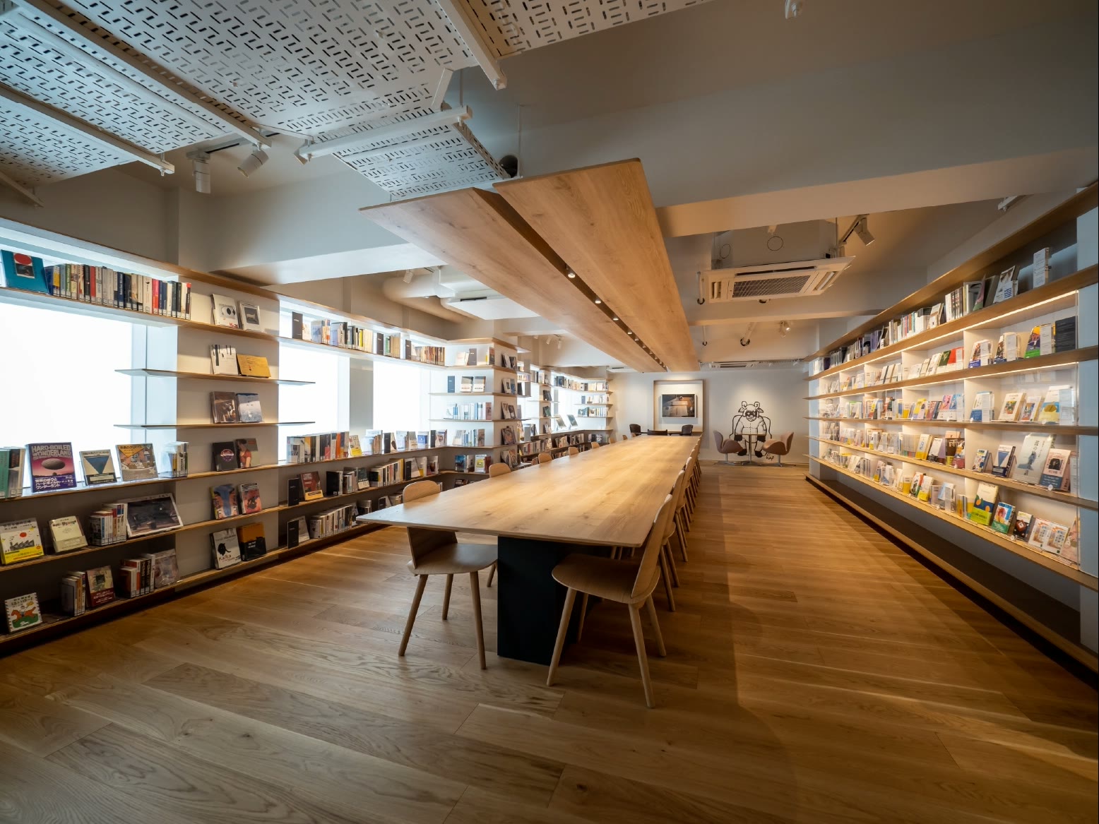 The interior of the Haruki Murakami Library with bookshelves and a long wooden table